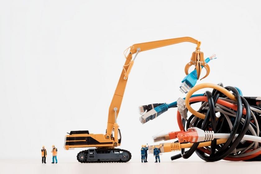 toy construction workers and construction equipment trying to put together giant, colorful ethernet cables