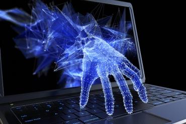 blue digital hand creeping out of a laptop screen and typing on the keyboard when nobody's looking 